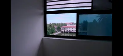 a window with a view of a large building at Padmalaya Homestay ! in Guruvāyūr