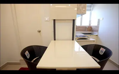 a kitchen with a white table and chairs at Padmalaya Homestay ! in Guruvāyūr