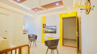 a living room with two chairs and a television at Padmalaya Homestay ! in Guruvāyūr