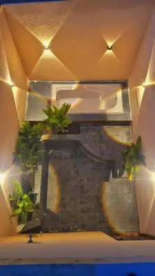 a kitchen with potted plants on a wall with lights at Eden Garden Bandipur Tiger Reserve in Gundlupet