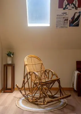 a wicker rocking chair in a room with a window at Lolo's by Raho - Loft Stay in Coorg in Ammatti