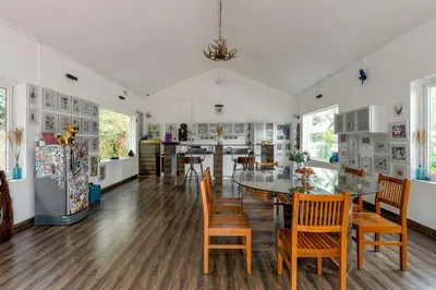 a kitchen and dining room with a table and chairs at Lolo's by Raho - Loft Stay in Coorg in Ammatti