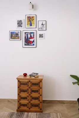 a room with a wooden dresser and pictures on the wall at Okka by Raho - A colonial style villa in Coorg in Siddapur