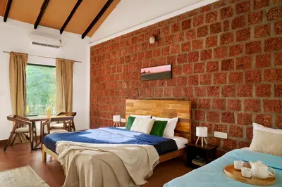 a bedroom with two beds and a brick wall at Nila by Raho - Secluded Villa with Estate View in Siddapur
