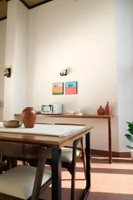 a dining room with a wooden table with chairs at Nila by Raho - Secluded Villa with Estate View in Siddapur