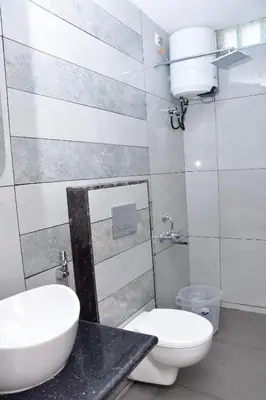 a bathroom with a white toilet and a sink at LaFiesta in Kodaikānāl