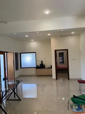 a large room with a screen on the wall at Calm Serenity Homestay in Kozhikode