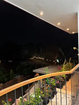 a balcony at night with potted plants at Calm Serenity Homestay in Kozhikode