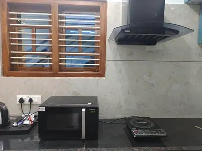 a microwave sitting on top of a counter in a kitchen at Vani Vilas Luxury Villa in Mysore