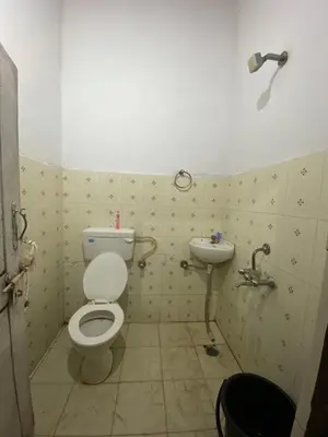 a bathroom with a toilet and a sink at Nirvana Private Villa in Kushālnagar