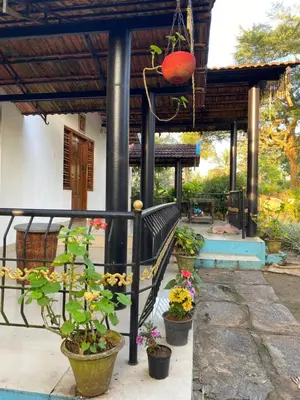 a porch with potted plants and a bench at Nirvana Private Villa in Kushālnagar