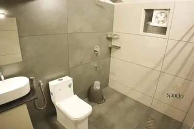 a small bathroom with a toilet and a sink at Hotel Spacio in Kozhikode