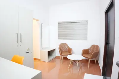 a room with two chairs and a table and a window at Hotel Spacio in Kozhikode