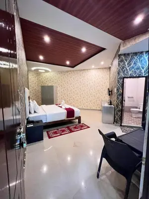 a bedroom with a bed and a bathroom with a tub at Plumeria Resort Coorg in Kushālnagar