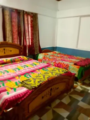 two beds sitting next to each other in a room at Varshini home stay in Kotagiri