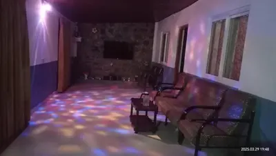 a living room with a couch and a tv at Varshini home stay in Kotagiri