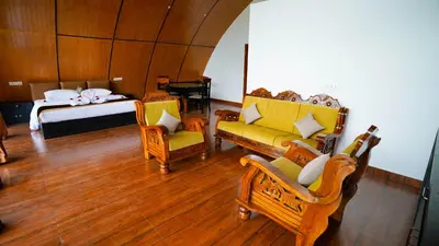 a living room with chairs and a bed with a bed at Era Resort Slope Stay in Kodaikānāl