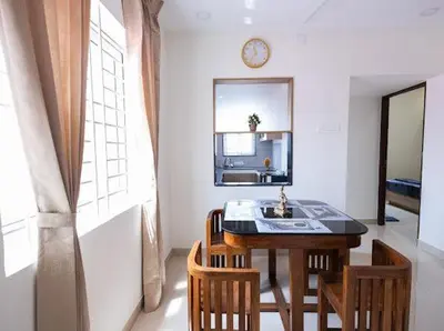 a kitchen with a table and chairs and a sink at Sree Home Stay and Service Apartment in Coimbatore