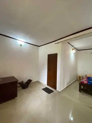 a white room with a door and a table at Coorg jungle Cottage in Kushālnagar