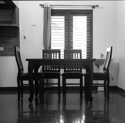 a dining room table with four chairs and a window at Nirmala Dhama Farmstay - Serene Family Retreat
