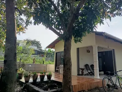 a house with a porch with a bike parked in front at Nihave in Attappādi