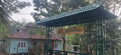 a sign in front of a house with a roof at Aura Eco Friendly Resort in Sultan Bathery