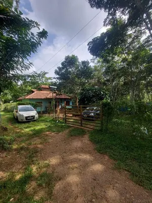 a car parked in front of a house with a fence at Aura Eco Friendly Resort in Sultan Bathery