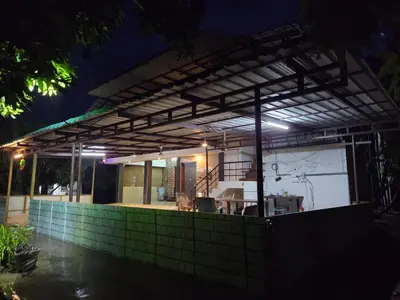 a house is lit up at night at Mango Bite Farmstay in Pollāchi