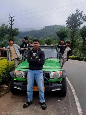 a group of men standing next to a green car at Mango Bite Farmstay in Pollāchi