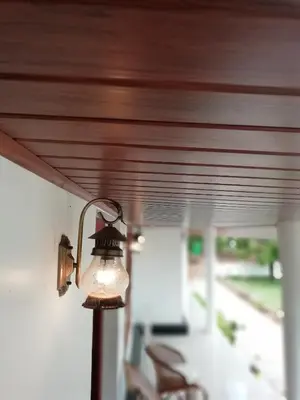 a light on the side of a porch at Salisbury Manor Heritage Inn in Marayoor