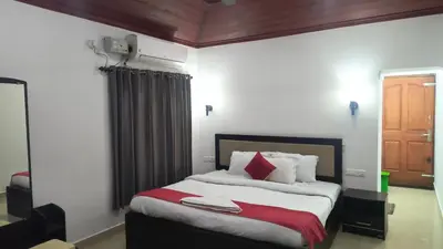 a bedroom with a large bed with red and white pillows at Salisbury Manor Heritage Inn in Marayoor