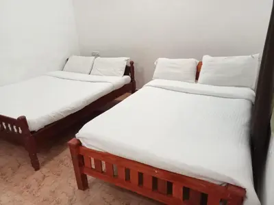 two twin beds in a room with white sheets at Jungle Mist Cottages in Masinagudi