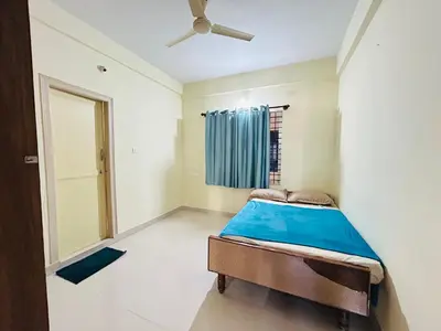 a bedroom with a bed and a ceiling fan at Raya 2 bhk flats in Mysore