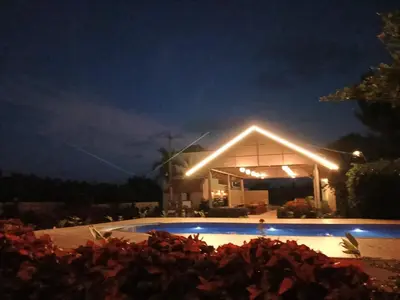 a lit up building with a pool at night at The fox resort in Bandipūr