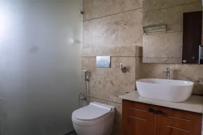 a bathroom with a white toilet and a sink at The fox resort in Bandipūr
