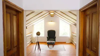 a hallway with a black chair in a room at 3 Bhk Villa Ooty - Casa de Amor by EBR in Ooty