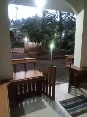 a window with two benches on a patio at night at Winter Valley Home Stay in Vythiri