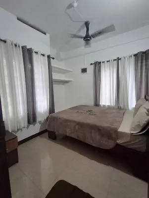 a bedroom with a bed and a ceiling fan at Winter Valley Home Stay in Vythiri