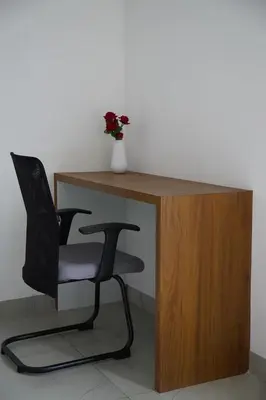 a desk with a chair and a vase of flowers at KK Service Suites in Coimbatore
