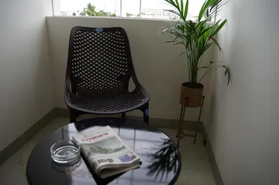 a chair and a glass table with a book on it at KK Service Suites in Coimbatore