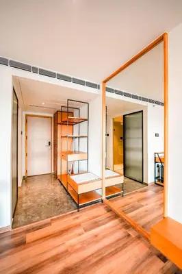 a large mirror in a room with wooden floors at Nestlay Suites by TC One in Kozhikode