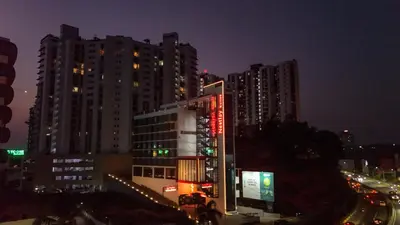 a city at night with tall buildings and traffic at Nestlay Suites by TC One in Kozhikode