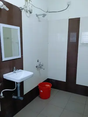 a bathroom with a sink and a red trash can at Siddhartha Residency in Mysore
