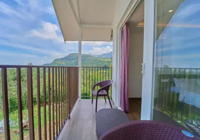 a balcony with chairs and a view of a mountain at Gardenia Pool Resort Kanthalloor by VOYE HOMES Mountain View Stay Near Bhramaram view Point in Kanthalloor
