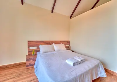a bedroom with a bed with two towels on it at Gardenia Pool Resort Kanthalloor by VOYE HOMES Mountain View Stay Near Bhramaram view Point in Kanthalloor