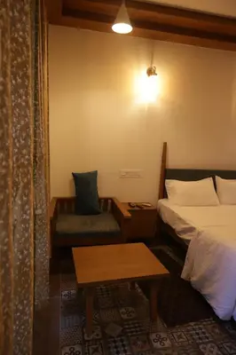 a hotel room with a bed and a chair at Castle DAK in Trichūr