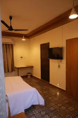a hotel room with a bed and a flat screen tv at Castle DAK in Trichūr