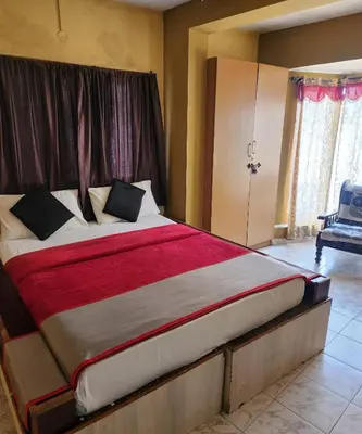 a bedroom with a large bed with a red blanket at DADIL HOME STAY ooty in Ooty