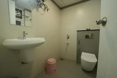 a bathroom with a sink and a toilet at Mirage Luxuria Inn in Vythiri