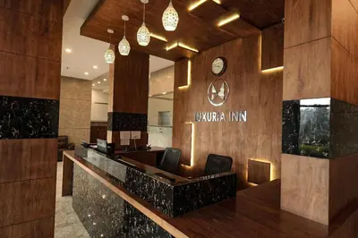 a lobby with a desk and chairs and a clock at Mirage Luxuria Inn in Vythiri